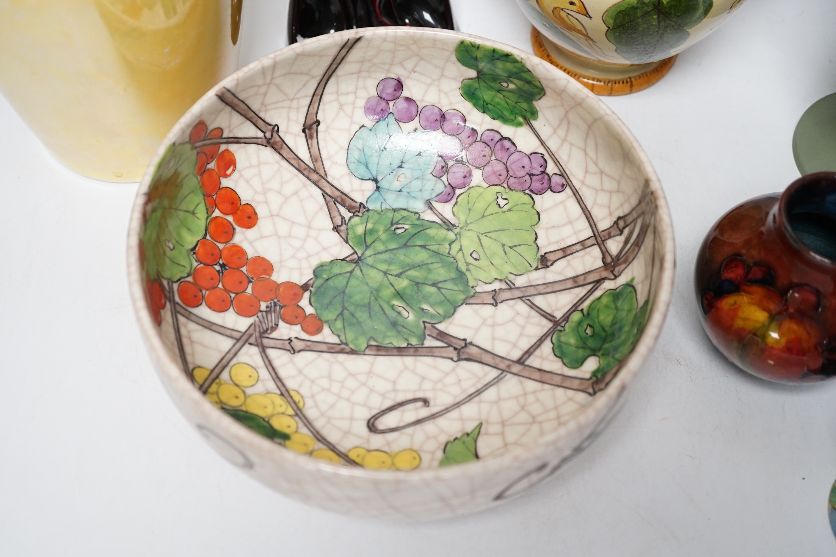 Five ceramic items including a Wedgwood pedestal vase, a Ruskin lustre glaze vase, a Doulton flambé 'The Genie', etc.